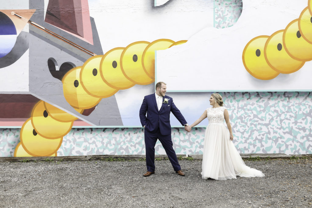 Tampa Bay Bride and Groom In Front of Retro Wall Art Mural at NOVA 535 Wedding Venue by Artists The Low Bros in the Edge District of Downtown St. Petersburg | Florida Wedding Photographer Lifelong Photography Studios