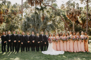 Florida bride and groom, bridesmaids in mix and match pink dresses holding berry colored floral bouquets, groomsmen in black suits | Tampa Bay Wedding Planner Special Moments Event Planning | Wedding Hair and Makeup Michele Renee the Studio