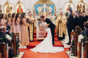 Traditional bride and groom exchanging wedding ceremony first kiss as man and wife | St. Petersburg Wedding Venue St. Stefanos Greek Church