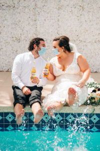 Intimate Backyard COVID Wedding | Bride and Groom Portrait with Face Masks and Corona Bottles | Lace Aline Martina Liana Wedding Dress Bridal Gown with Cathedral Veil | Groom in Classic Black Tux by Indochino
