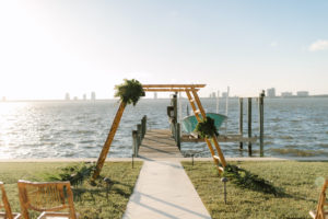 Tropical Modern Waterfront Wedding Ceremony Decor, Bamboo Ladder Arch with Monstera Palm Tree Leaf Arrangements | Tampa Bay Wedding Planner, Florist and Designer John Campbell Weddings