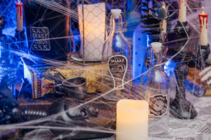 Spooky Halloween Wedding Reception Decor, Table Covered in Cobwebs with Black Candlesticks and Bottles | Tampa Bay Wedding Planner UNIQUE Weddings and Events