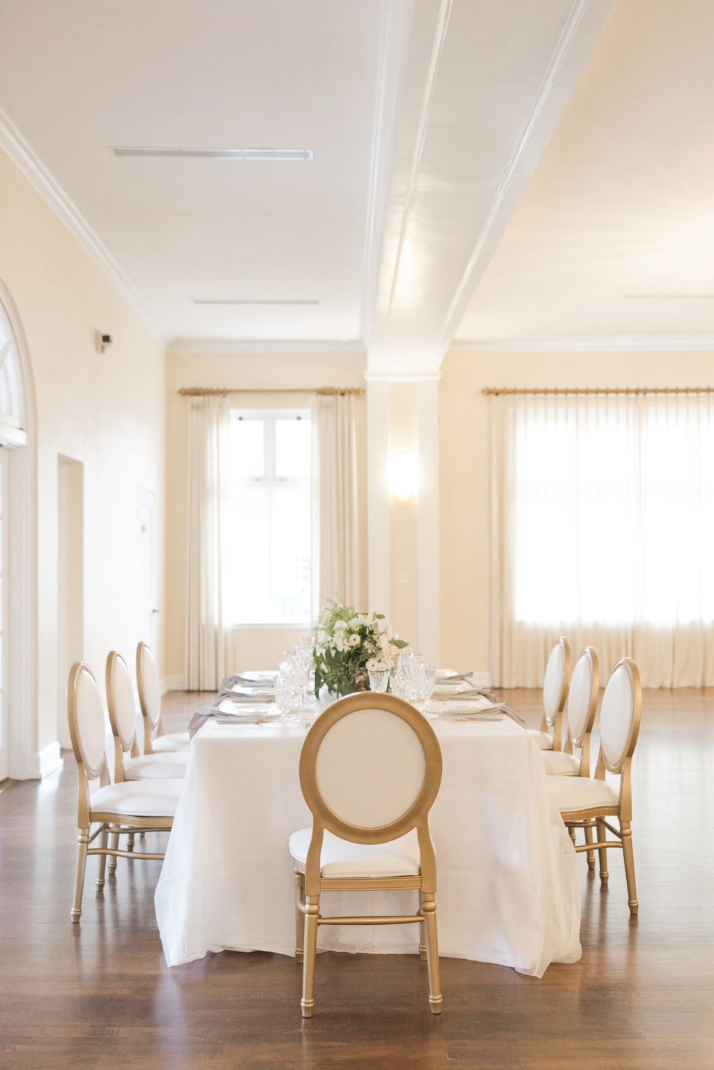 Southern Charm classic and traditional wedding reception decor, long table with white tablecloth, Louis XVI Chair and lush white floral centerpiece | Tampa Bay wedding planner and design Elegant Affairs by Design | Kate Ryan Event Rentals