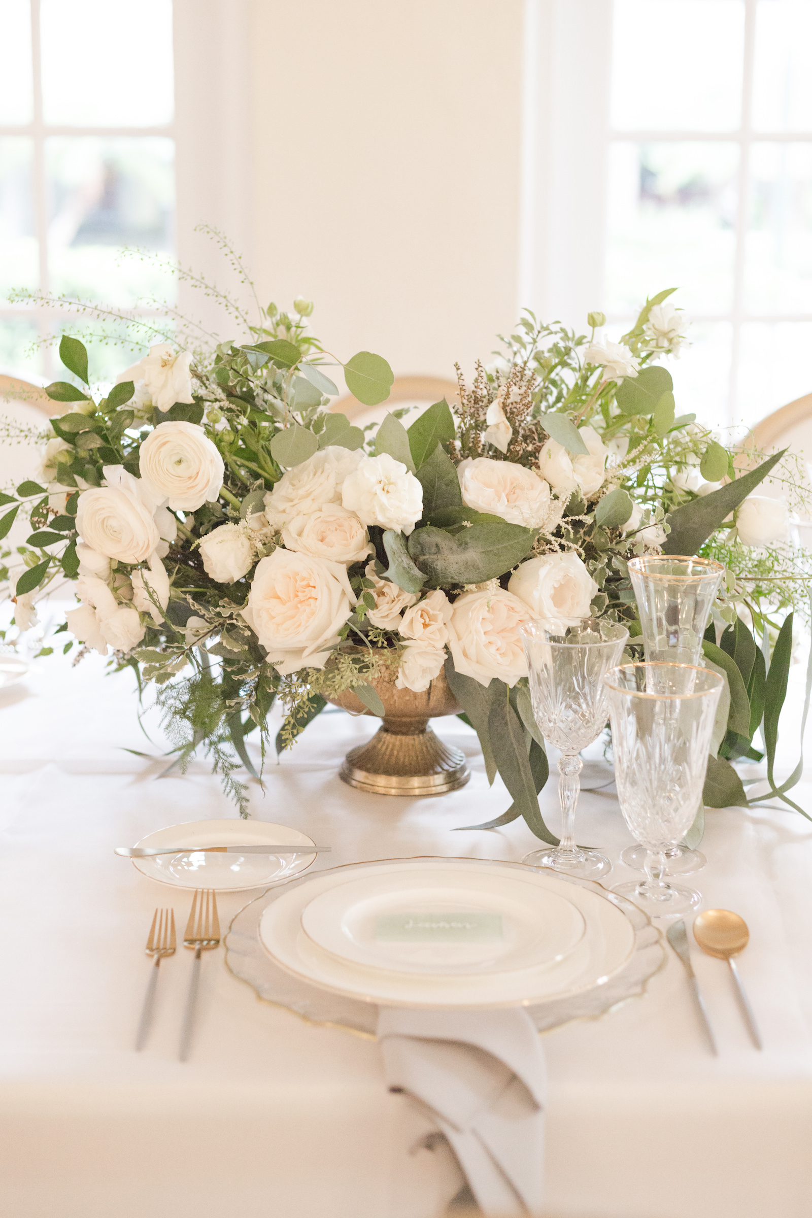 Southern Charm classic and timeless wedding reception decor, gold flatware, lush ivory roses, eucalyptus and greenery low floral centerpiece | Tampa Bay wedding planner and design Elegant Affairs by Design | Kate Ryan Event Rentals