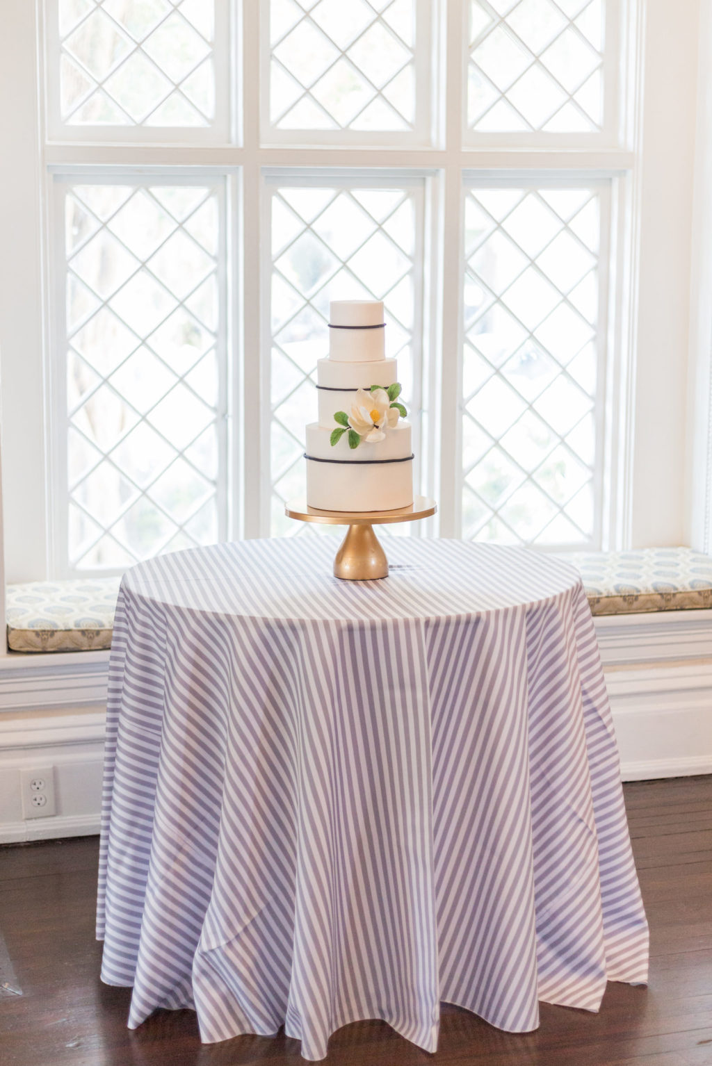 Classic three tier white and blue wedding cake with flower on table with blue striped tablecloth | Tampa Bay wedding planner Elegant Affairs by Design | Tampa Bay Cake Company