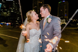 Bride and Groom Outdoor Night Portrait with Sparklers | COVID Tampa Downtown Wedding | Groom in Grey Silver Suit with Blush Pink Tie and Rose Boutonniere