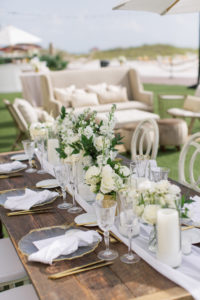 Garden-style wedding reception decor, clear and gold rimmed chargers, gold flatware, white linens and custom stationery | Tampa Bay wedding planner Parties A'la Carte | Kate Ryan Event Rentals