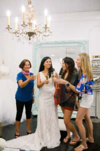Tampa Bay bride and bridal party cheering with glass of champagne after saying yes to the dress at boutique bridal shop Isabel O'Neil Collection