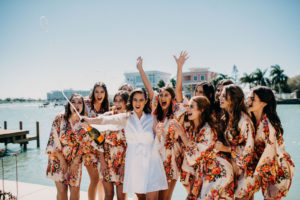 Tampa Bride and Bridesmaids in Matching Floral Robes Popping Bottle of Champagne Waterfront Photo | Wedding Hair and Makeup Michele Renee the Studio