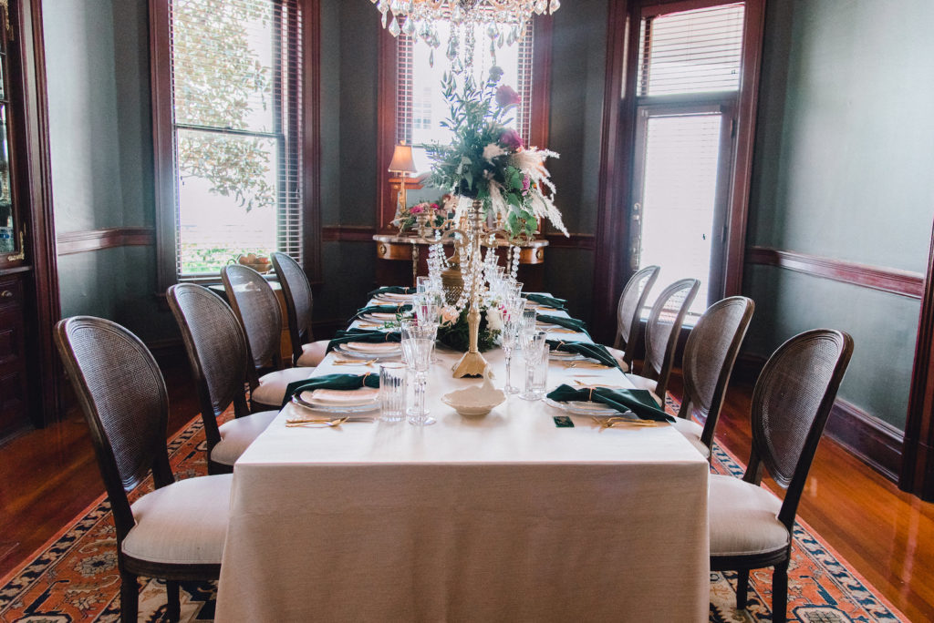 Art Nouveau Wedding Reception Decor, Long Table with Jewel Toned Florals, Greenery and Feathers Centerpiece on Gold Candelabra with Hanging Crystals, Emerald Green Napkins | Tampa Bay Wedding Planner EventFull Weddings | Historic Wedding Venue Anderson House | Kate Ryan Event Rentals