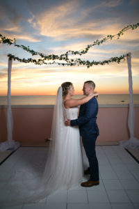Florida Bride and Groom Dancing on Waterfront Hotel Rooftop Balcony, White Dance Floor and Hanging Greenery, Bride in Flowy Lace and Tulle Wedding Dress and Full Length Veil | Tampa Bay Wedding Photographer Carrie Wildes | Wedding Venue Hyatt Regency Clearwater Beach | Wedding Attire Truly Forever Bridal | Wedding Rentals Outside the Box | Wedding Planner Coastal Coordinating