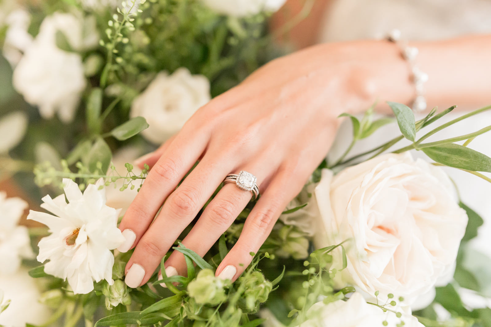 Tampa bride with round diamond engagement ring with halo on white floral bouquet