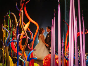 Halloween Bride and Groom Photo Behind Colorful Whimsical Chihuly Collection Glass Sculptures
