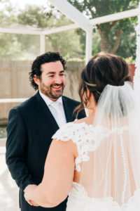 Intimate Backyard COVID Wedding | Bride and Groom First Look | Lace Aline Martina Liana Wedding Dress Bridal Gown with Cathedral Veil | Groom in Classic Black Tux by Indochino