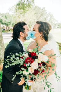 Intimate Backyard COVID Wedding | Bride and Groom Portrait with Face Masks | Lace Aline Martina Liana Wedding Dress Bridal Gown with Cathedral Veil | Groom in Classic Black Tux by Indochino | Red White and Blue Wedding Bouquet with Roses Ranunculus and Greenery
