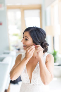 Happy smiling bride with updo wearing plunging v neckline lace wedding dress from boutique bridal shop Isabel O'Neil