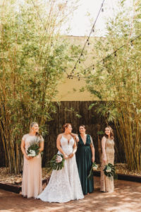 Modern Tropical Inspired Florida Wedding Party in Bamboo Garden, Bridesmaids in Long Mixed Style Dresses, Dark Green, Gold Sequined and Light Pink, Bride Wearing Blush By Hayley Paige Ivory Delta Gown, Holding DIY King Protea Monstera Leaf Bouquets | Unique Tampa Bay Wedding Venue NOVA 535 in Downtown St. Pete - Courtyard