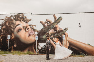 Tampa Bay Bride and Groom in front of St. Pete Wall Mural from SHINE Festival, Mask Off by Drew Merritt, Edge District of Downtown Saint Petersburg, Florida Bride Wearing Blush By Hayley Paige Delta Gown
