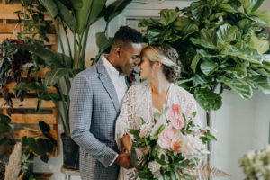 Boho Neutral Styled Shoot | Bohemian Bride in Vintage Lace and Fringe Short Sleeve Wedding Dress, Groom in Gray Plaid Suit Exchanging Vows, Tropical Inspired Flora Bouquet, Palm Tree Leaves, Pink Anthurium, Ivory Flowers | Unique St. Pete Wedding Venue Wild Roots Nursery | Wedding Planner Elope Tampa Bay | Amber McWhorter Photography