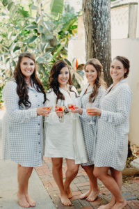 Bride and Bridesmaids Portrait Shot Getting Ready with Blue Flannel Gingham Pajama Shirts and Champagne
