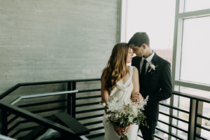 Modern Industrial Bride and Groom Holding All White Neutral Floral Bouquet | Tampa Bay Wedding Planner Elope Tampa Bay | Wedding Venue Rooftop 220 | Wedding Photographer Amber McWhorter