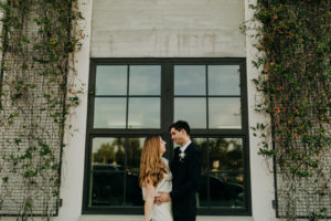 Modern Industrial Bride and Groom Holding All White Neutral Floral Bouquet | Tampa Bay Wedding Planner Elope Tampa Bay | Wedding Venue Rooftop 220 | Wedding Photographer Amber McWhorter