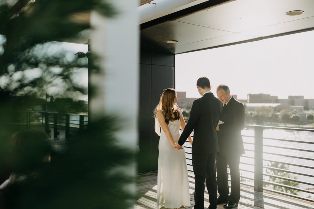 Modern Industrial Bride and Groom Exchanging Wedding Vows on Rooftop Ceremony | Tampa Wedding Venue Rooftop 220 | Wedding Planner Elope Tampa Bay | Wedding Photographer Amber McWhorter