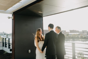 Modern Industrial Bride and Groom Exchanging Wedding Vows on Rooftop Ceremony | Tampa Wedding Venue Rooftop 220 | Wedding Planner Elope Tampa Bay | Wedding Photographer Amber McWhorter