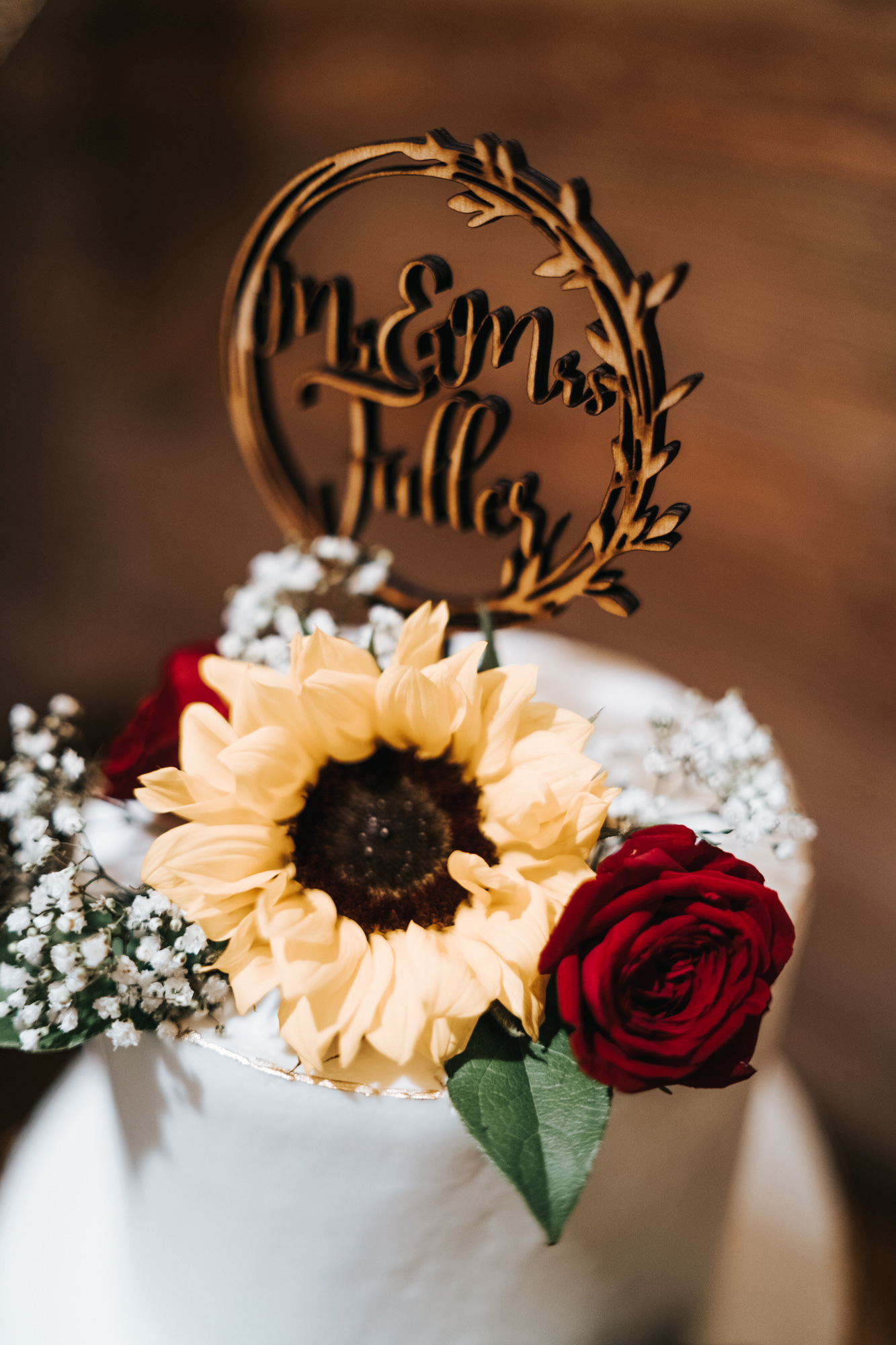 Wedding Cake with Yellow Sunflowers and Red Roses and Baby's Breath topped with Die Cut Wood Name Cake Topper