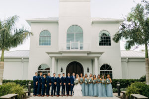 Classic Bride, Groom, Bridesmaids in Dusty Blue Matching Dresses, Groomsmen in Navy Blue Suits Outside Safety harbor Wedding Venue Harborside Chapel | Tampa Bay Wedding Photographer Amber McWhorter Photography