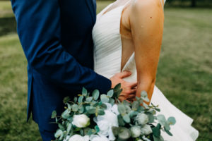 Classic Bride in V Neckline Wedding Dress Holding Eucalyptus Greenery and White Floral Bouquet with Groom in Blue Suit | Tampa Bay Wedding Photographer Amber McWhorter Photography