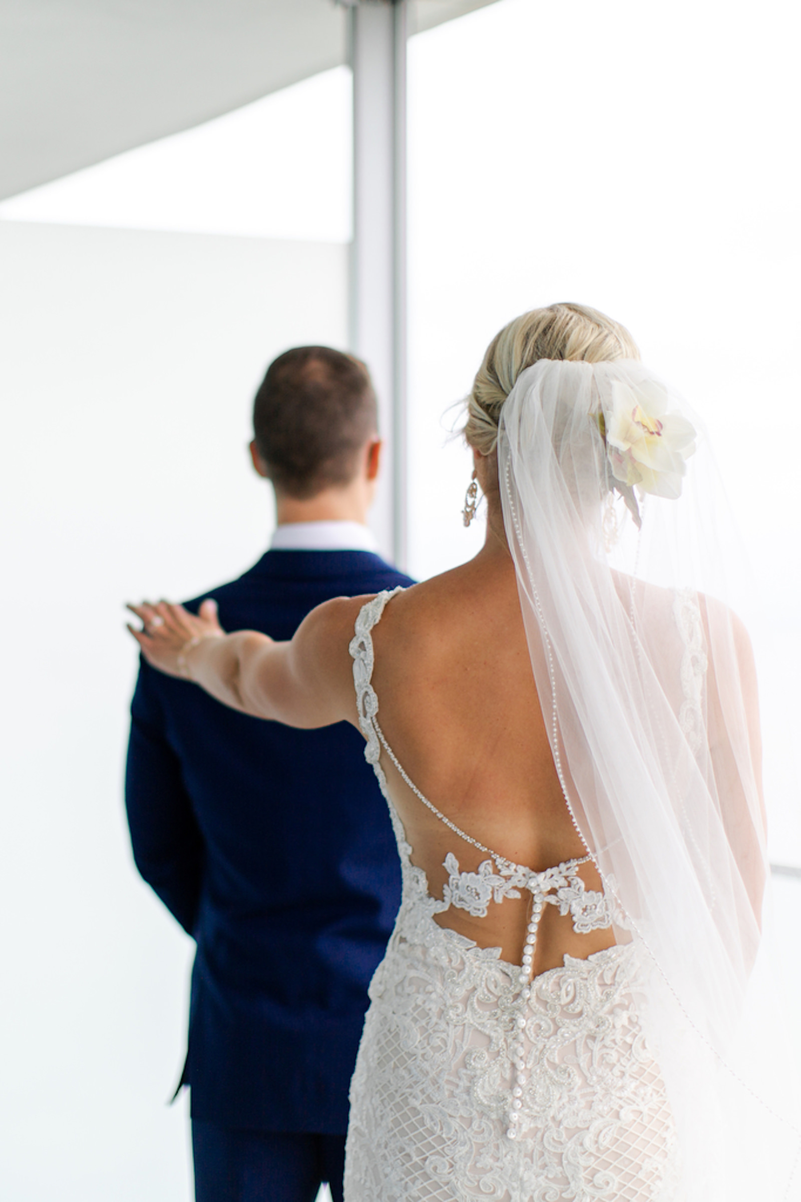 Tropical Florida Bride in Lace and Illusion Low Open Back Wedding Dress with Pearl Buttons First Look Picture with Groom
