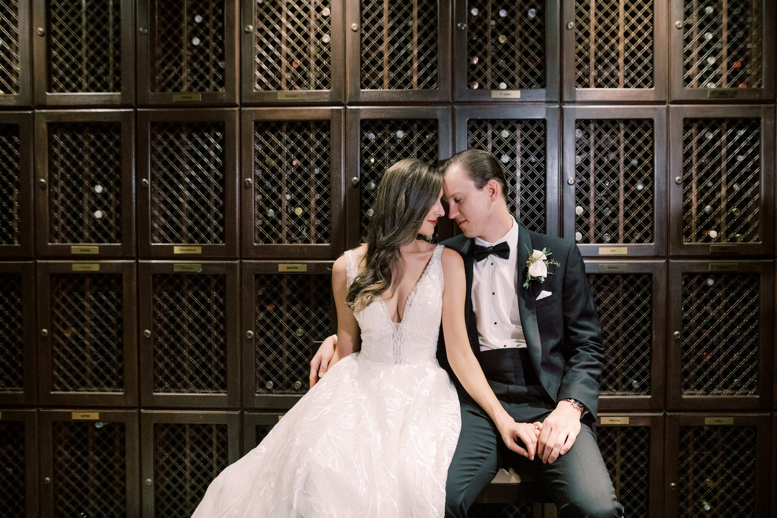 Indoor Bride and Groom Portrait at Downtown Tampa Wedding Venue The Tampa Club Wine Room | V Neck Embroidered Illusion Panel Allure Couture Designer Wedding Dress Bridal Gown | Groom in Classic Black Suit Tux with Bow Tie