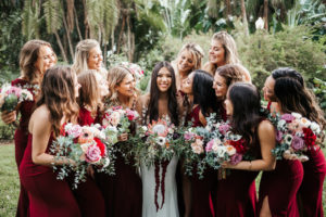St. Petersburg Bride and Bridal Party, Holding Exotic Tropical Inspired Bridal Bouquet with Bright Pink King Protea, White, Dark Purple, Burgundy, Wine Florals with Greenery, Bridesmaids in Long Mismatched BHLDN Dresses in Dark Burgundy and Wine Color | Florida Wedding Florist Posies Flower Truck | Tampa Bay Wedding Planner John Campbell Weddings