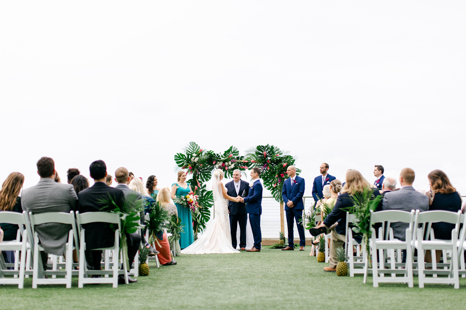 Tropical Elegant Wedding Ceremony, Bride and Groom Exchanging Vows Under Arch with Monstera Palm Tree Leaves, Pink Ginger Florals | Tampa Bay Wedding Planner Special Moments Event Planning | Clearwater Beach Opal Sands Resort