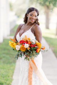 Modern Boho Florida Bride Holding Bridal Bouquet, Wearing White Mermaid Style Wedding Gown with V Neckline and Straps, Autumn-Inspired Wedding Bouquet, Holding Triadic Orange Color Palette, Red Posies, Yellow Flowers, Ivory Roses, Orange Florals with Dark Greenery | Tampa Bay Wedding Planner Coastal Coordinating, Jessica Zenobi