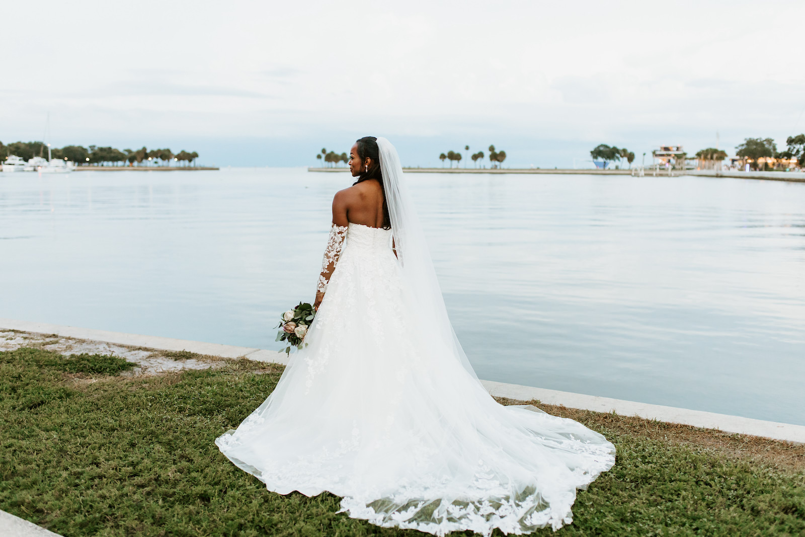 Waterfront Outdoor Bridal Portrait in Downtown St. Pete | Ballgown Lace Sweetheart Neckline Tulle Wedding Dress with Sheer Illusion Lace Sleeves and Cathedral Veil