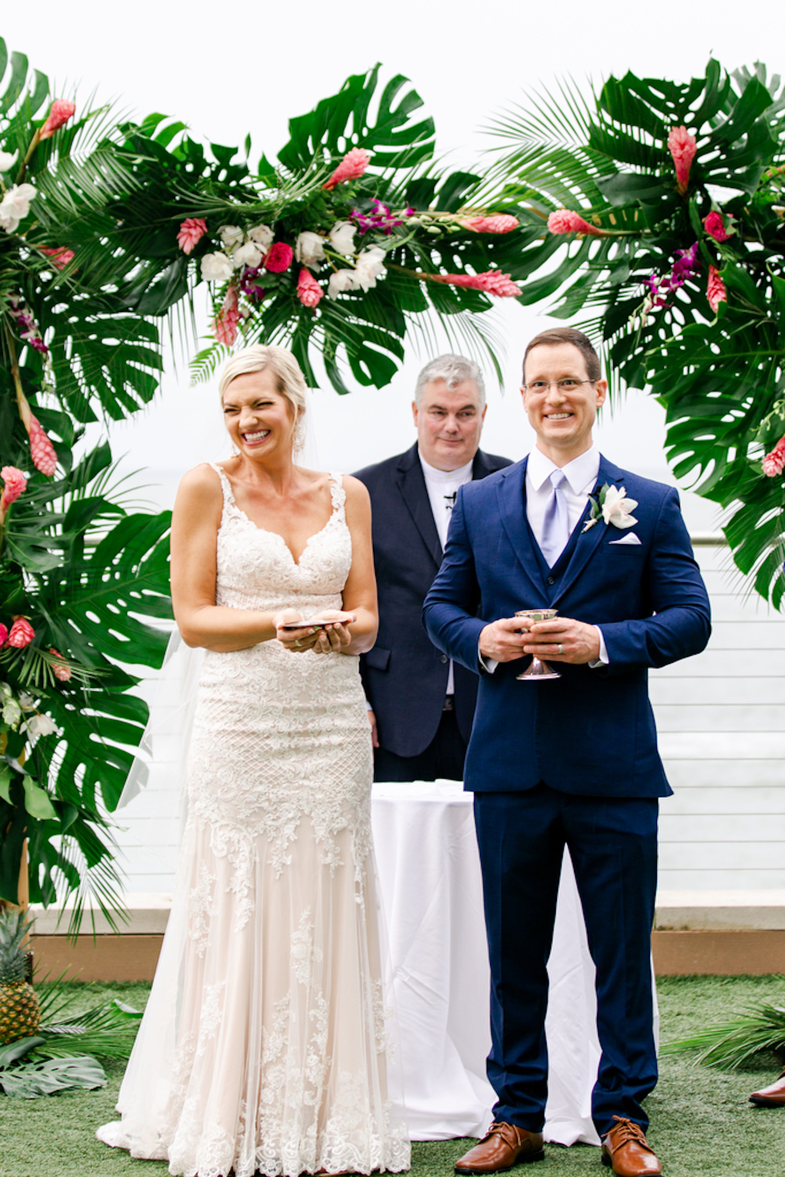 Tropical Elegant Wedding Ceremony, Bride and Groom Exchanging Wedding Vows Under Arch with Monstera Palm Tree Leaves, Pink Ginger, Purple and White Floral Arrangements | Tampa Bay Wedding Planner Special Moments Event Planning | Waterfront Clearwater Beach Opal Sands Resort