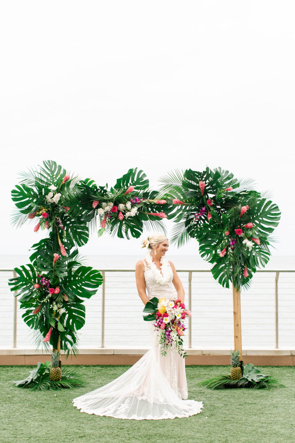 Tropical Elegant Bride Under Arch with Monstera Palm Tree Leaves, Pink Ginger, Purple Orchids, White Flowers | Tampa Bay Wedding Planner Special Moments Event Planning | Waterfront Clearwater Beach Opal Sands Resort