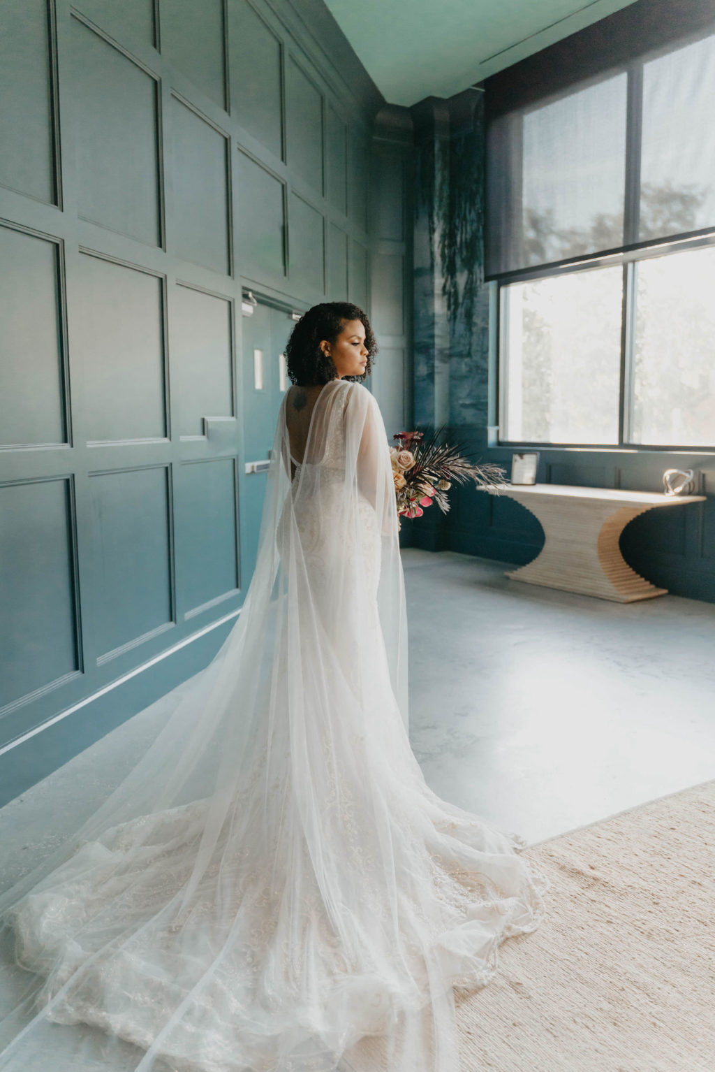 Indoor Bridal Portrait in Tampa Wedding Venue Hyde House | Illusion Lace Embroidered Beaded V Neck Wedding Dress Bridal Gown with Sheer Tulle Cape Sleeves by Designer Amalia Carrara Bridal