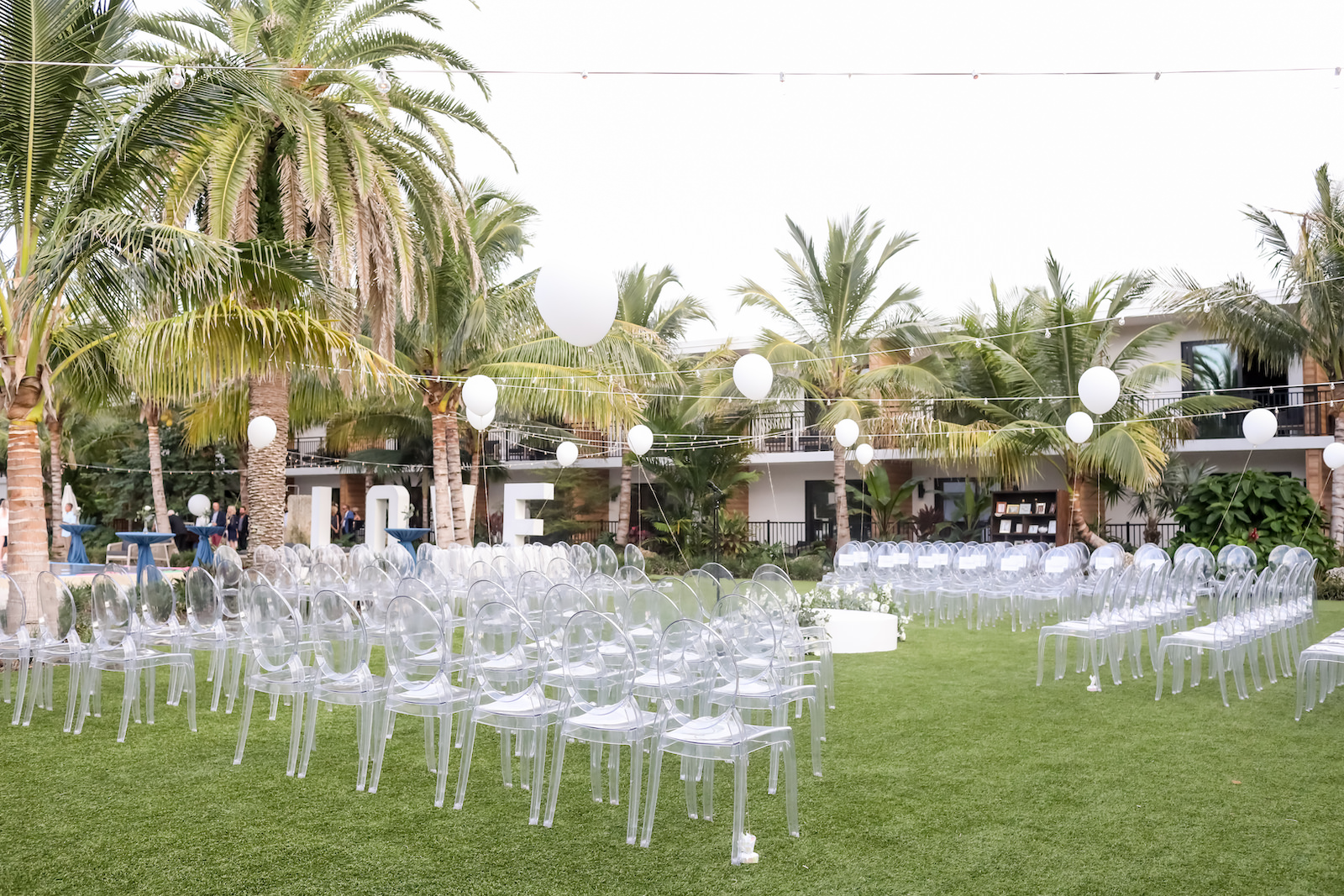 Romantic, Modern Outdoor Florida Wedding Ceremony at Bali Hai Beachfront Resort Anna Marie Island, Acrylic Ghost Chair Rentals with White Balloons and LOVE Lettering | Sarasota Wedding Planner Kelly Kennedy Weddings | Tampa Bay Wedding Photographer Lifelong Photography Studio