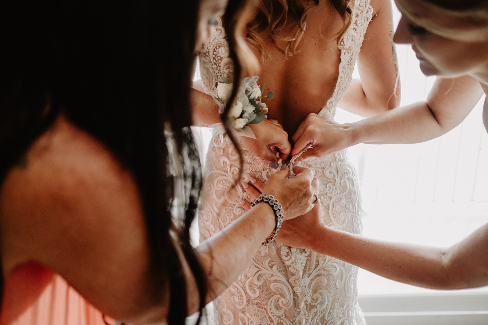 Bridesmaids Helping Bride Get Ready Shot | Allure Bridals Lace Low Back Bridal Gown Wedding Dress
