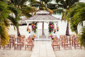 Vibrant Pink, Yellow, and Green Tropical Beach Wedding Ceremony with Bamboo Chairs | St. Petersburg Wedding Venue Isla Del Sol Yacht and Country Club