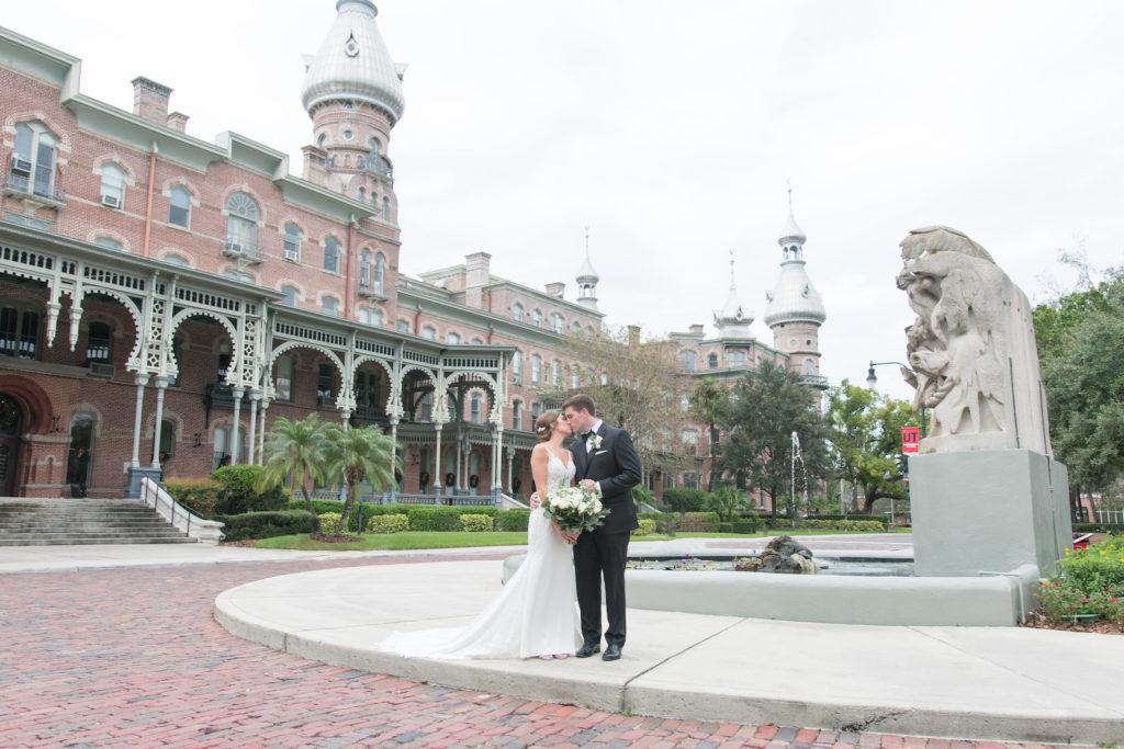 Downtown Tampa Wedding Bride and Groom Outdoor Portrait at University of Tampa Plant Museum | Groom Wearing Classic Black Suit Tux | Stella York Designer Illusion Lace V Neck Sheath Chiffon Satin Wedding Dress Bridal Gown | Carrie Wildes Photography