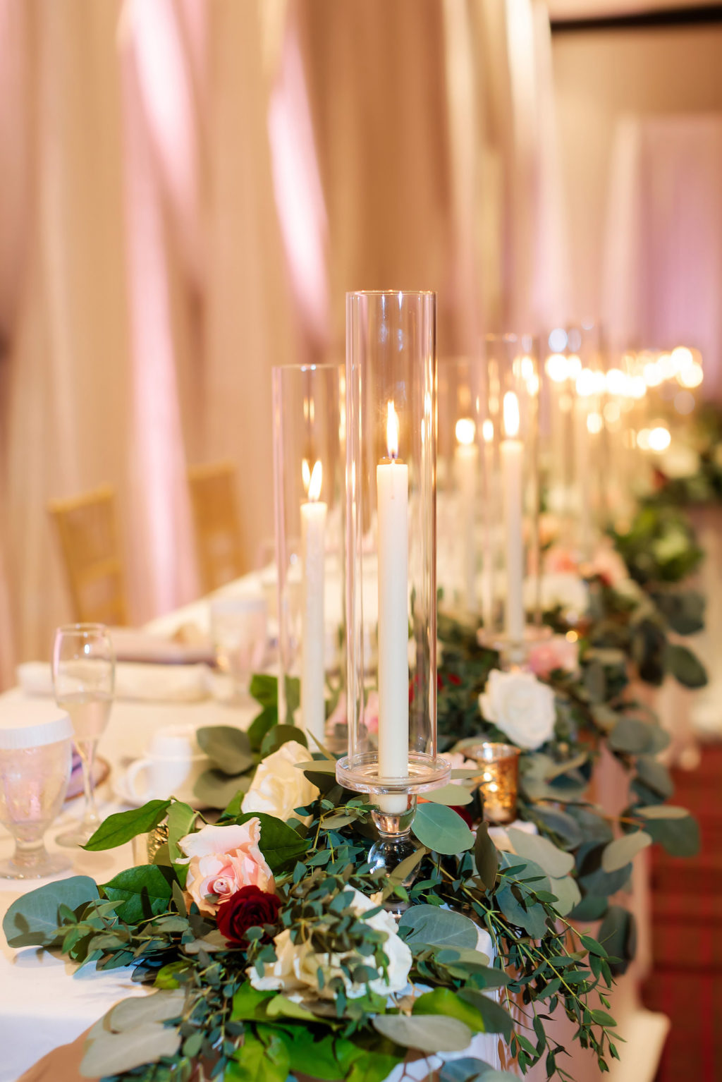 Tampa Wedding Reception Long Feasting Head Table with Greenery Garland and Taper Candles by Tampa Wedding Florist Monarch Events and Design