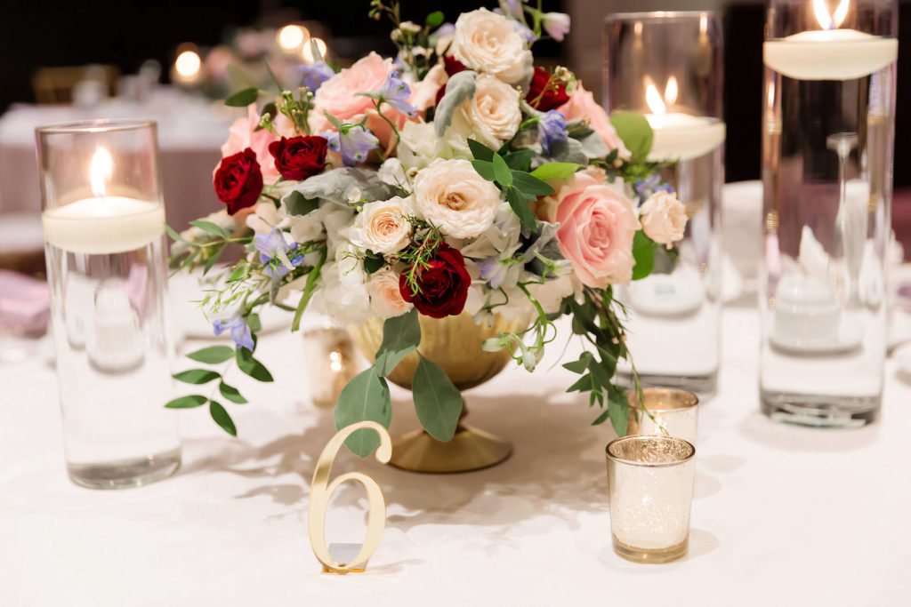 Tampa Wedding Low Gold Vase Centerpieces of White, Red and Blush Pink Roses and Blue Delphinium with Greenery, Gold Mercury Glass Votives and Floating Candles by Tampa Wedding Florist Monarch Events and Design