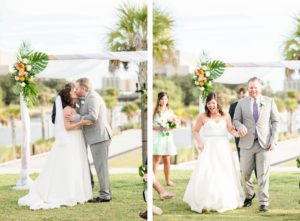 Florida Tropical Bride and Groom Exchanging First Kiss During Wedding Ceremony, Arch with White Linens and Monstera Leaves, Pink, Yellow and White Floral Arrangements | Tampa Bay Wedding Planner Coastal Coordinating | Wedding Hair and Makeup Adore Bridal