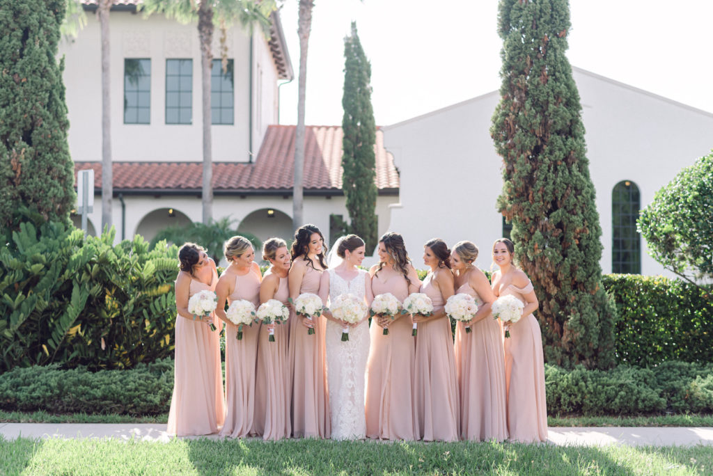 Romantic Bride and Bridesmaids in Blush Mix and Match Dresses Holding White Floral Bouquets | Tampa Wedding Venue Westshore Yacht Club | Wedding Hair and Makeup Femme Akoi | Bella Bridesmaids