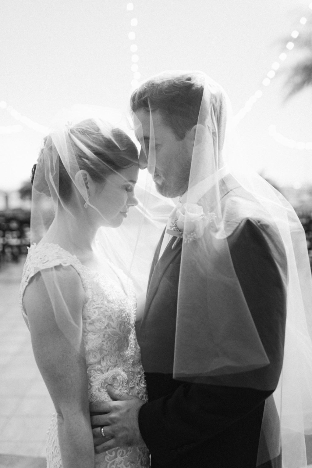 Romantic Intimate Black and White Portrait of Bride and Groom Under Wedding Veil