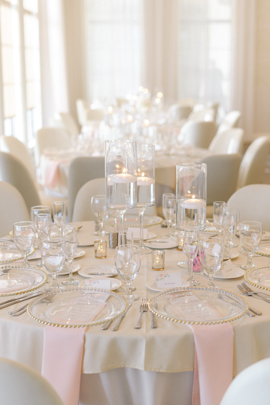 Romantic Classic Wedding Reception Decor, Ivory Chairs, Blush Pink Linen Napkins, Tall and Low Floating Hurricane Candles | Tampa Wedding Venue Westshore Yacht Club